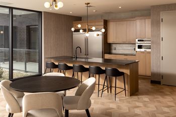 Social room featuring seating and view into catering kitchen featuring breakfast bar seating